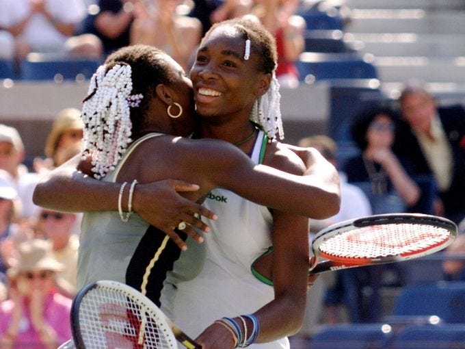 Venus Williams (rt) hugs her sister Serena after winning the doubles title at the 1999 U.S. Open