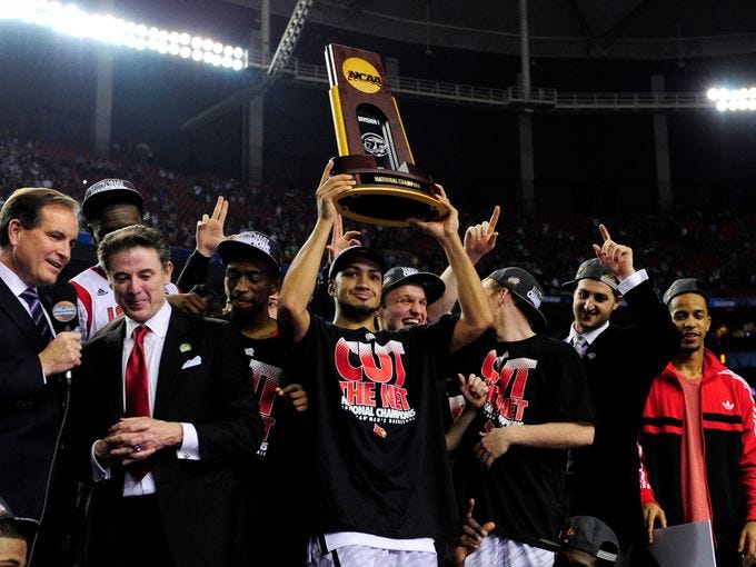 Louisville Cardinals guard Peyton Siva holds the trophy after Louisville won the championship game against the Michigan Wolverines at the Georgia Dome.