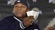 Mayweather tosses a roll of dollars to fans at a news conference for WrestleMania in 2008.