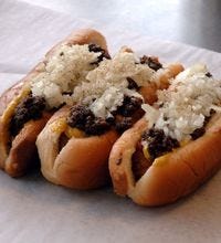 Olneyville N.Y. System, North Providence, R.I.: NY System Dog; The New York System dog is a regional specialty: small franks (in this case, from Little Rhody) are steamed, placed atop a steamed bun, and topped with a cumin-heavy meat sauce, yellow mustard, diced onions, and celery salt. You're going to want to order a few of these, because they're small and addictive (see how many of them the counterman can balance on his arm). The 