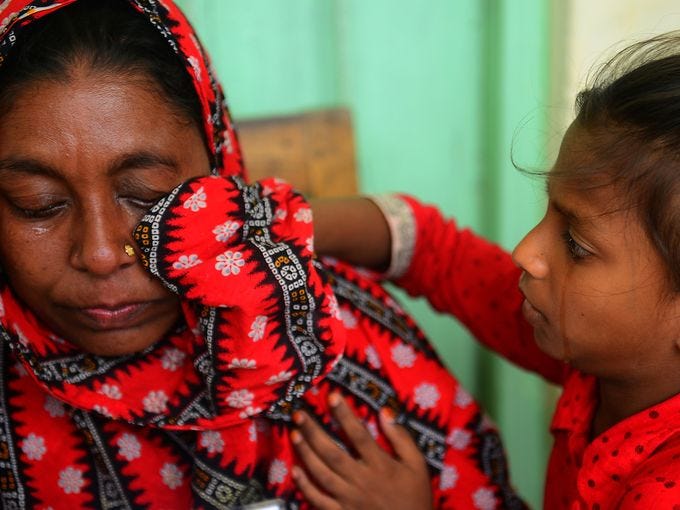 A child wipes tears from her mother's face after they found out several relatives died in a building collapse on May 13 in Savar, Bangladesh. The army is stopping a search for survivors as the death toll of the April 24 collapse of an eight-story building housing several garment factories climbed to over 1,127 people.