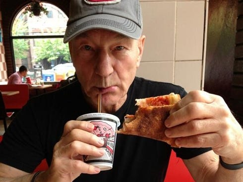 The star is enjoying his first piece of NY pizza.