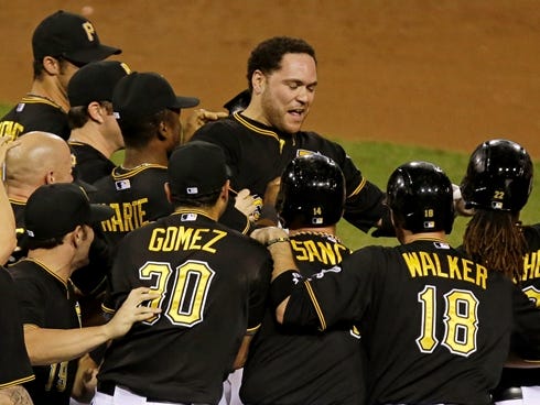 Pirates'  Russell Martin, top center, celebrates with teammates after hitting a walk-off single to deep center field on Thursday.