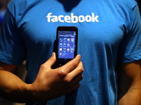 A Facebook employee holds a phone running the company's new 