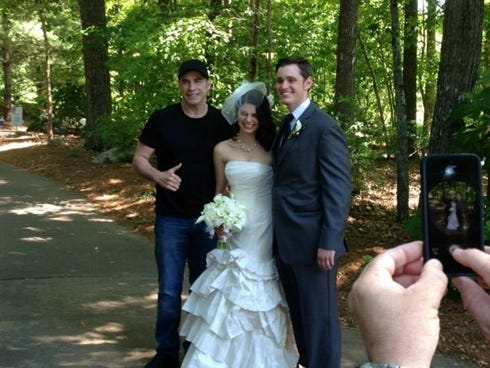 John Travolta poses with the bride and groom.