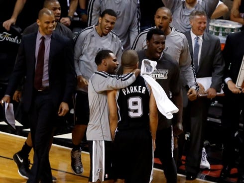 Spurs point guard Tony Parker is surrounded by teammates after making the key shot in Game 1 of the NBA Finals on Thursday.