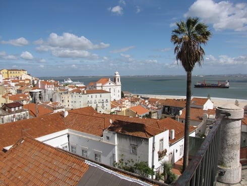 The red-tiled rooftops of Lisbon, Portugal's capital, spill to the banks of the Tagus River where it flows into the Atlantic Ocean. Portugese receive a great deal of vacation time.