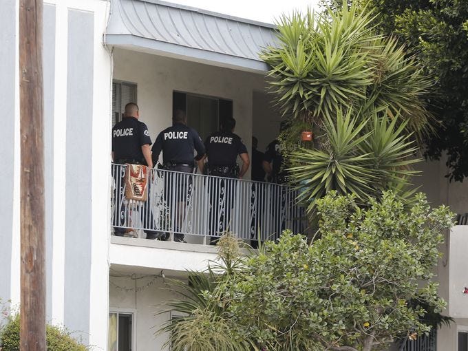 Los Angeles police officers check a home in the city's westside Palms district, that was believed to be connected in some way with shootings in nearby Santa Monica.