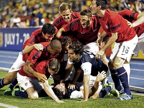 United States bench players congratulate teammate Brad Evans, who lies on the pitch, after scoring the winning goal in the second half of the 2014 World Cup qualifying soccer match against Jamaica in Kingston, Jamaica, Friday, June 7, 2013.