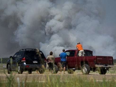 Motorists stop along Interquest Parkway in Colorado Springs, Colo., June 11, 2013, to watch the advance of a wildfire burning in Black Forest.