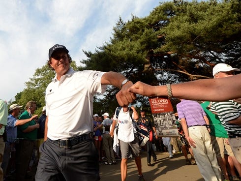 Phil Mickelson fist bumps a fan after walking off the 12th hole during the third round of the 113th U.S. Open.