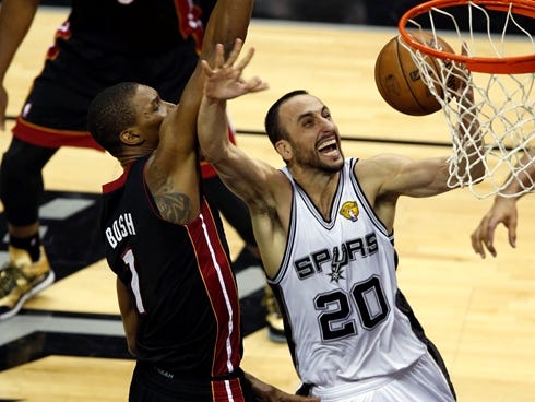 Spurs guard Manu Ginobili goes up for a layup in front of Heat center Chris Bosh during Game 5 of the NBA Finals.