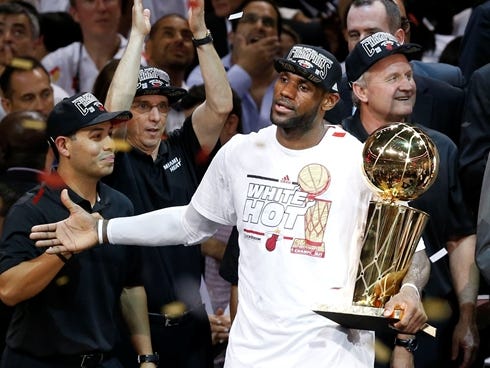 Heat forward LeBron James holds the Larry O'Brien Trophy after winning the NBA championship, his second time in as many years being able to do so.