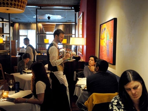 Server Thom Mathis tends to guests as they dine at Rick Bayless' Topolobampo restaurant in Chicago.