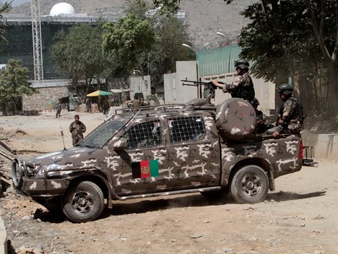 Afghan security forces block a road near the entrance gate of the presidential palace in Kabul.