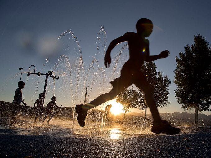 Ashawn Rabb runs through a fountain of water at the Red Ridge Park water park on June 27 in Las Vegas. A high pressure system stalled over the West is bringing high heat to a region used to baking during the summer.