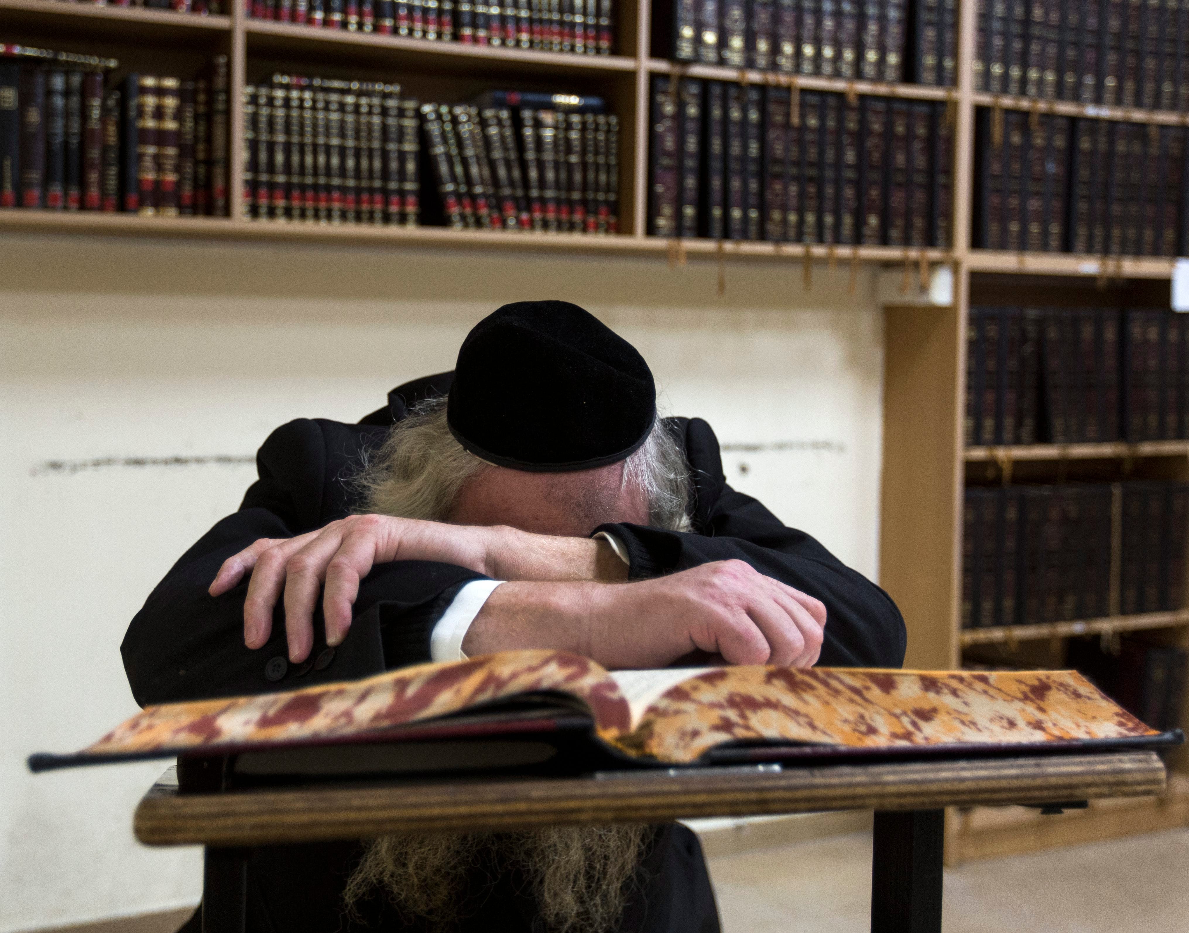 An elderly Jew is in deep prayer in the main hall of