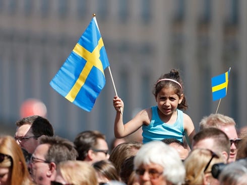 A girl waves with a Swedish flag outside the Royal castle in Stockholm.