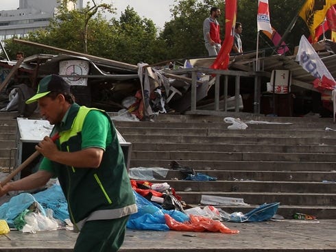 A municipality worker cleans the steps of Taksim Square under a barricade in Istanbul on Thursday.