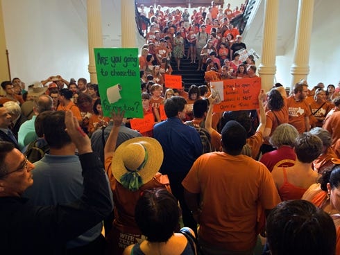 A large crowd, many wearing Planned Parenthood T-shirts that read ���Stand with Texas Woman,��� gather at the Texas State Capitol in Austin on Sunday.