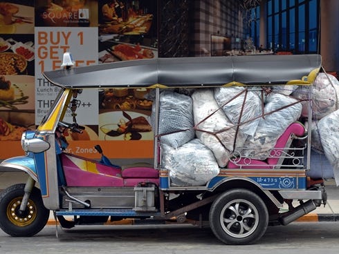 A Thai worker loads packs of clothes into a tuk-tuk at shopping mall in Bangkok. The city is forecast to be the world's No. 1 destination in terms of visitor arrivals in 2013.