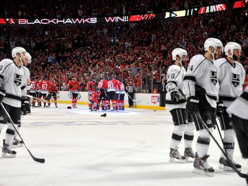 Chicago Blackhawks players celebrate after the game-winning goal by right wing Patrick Kane as Los Angeles Kings players skate off the ice after game five of the Western Conference finals of the 2013 Stanley Cup Playoffs at the United Center. The Bla