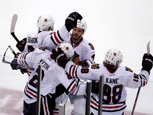 Chicago Blackhawks defenseman Brent Seabrook (7) celebrates with teammates after scoring the game-winning goal against the Boston Bruins during the overtime period in game four of the 2013 Stanley Cup Final at TD Garden.