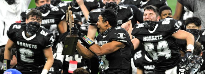 Julius Garza (3) de New Lothrop hurle alors qu'il brandit le trophée du championnat de son équipe.