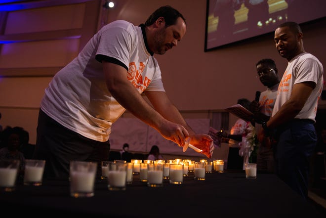 A man lit a candle at the Solid Rock Church during the vigilance of the victims of the recent Buffalo and Yuvalde shootings on Tuesday, May 31, 2022. Community members attended the NAACP event to mourn the lost lives and call for action.
