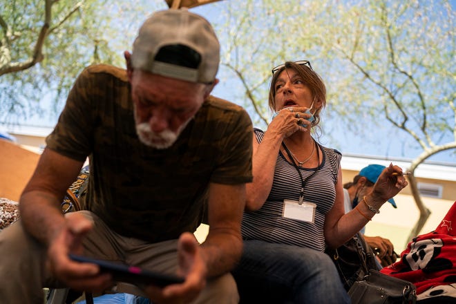 David (left) and his partner Vicky Alspaugh (right) sit in a shaded area at Central Arizona Shelter Services on Saturday, June 4, 2022, in Phoenix. The center has a number of shaded areas to mitigate the dangers of prolonged sun exposure for unhoused residents, especially during the summer.