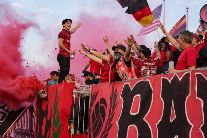 Phoenix Rising fans cheer, throw confetti and pop smokes as the game against the Tampa Rowdies begins at Phoenix Rising FC Stadium.