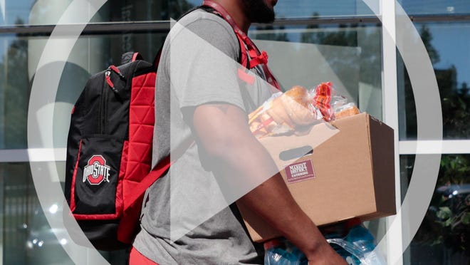 In this file photo Ohio State Buckeyes offensive lineman Thayer Munford carries a box of food and drinks as he leaves following a voluntary workout on Monday, June 8, 2020 at the Woody Hayes Athletic Center in Columbus, Ohio. Due to the ongoing COVID-19 pandemic, players are socially distanced during workouts and only arrive and leave in small groups.