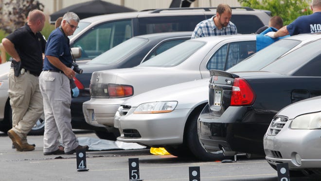 Police collect information at the scene following a shooting in the parking lot of Jordan Manufacturing Tuesday, August 5, 2014, at 1200 S. Sixth in Monticello. According to White County Sheriff Patrick Shafer, police found a man with a handgun dead in the parking lot shortly before noon. A second man was found dead in a car in the parking lot. A woman found in the passenger seat of the car was transported to IU Health White Memorial Hospital, where she was pronounced dead.