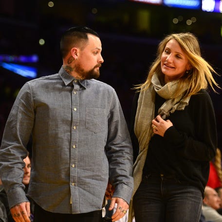 Cameron Diaz walks with her husband  Benji Madden as they attend the Los Angeles Lakers v. Washington Wizards NBA game at the Staples Center in Los Angeles, Calif on Jan. 27, 2015. Diaz and Madden were married Jan. 5, 2015.