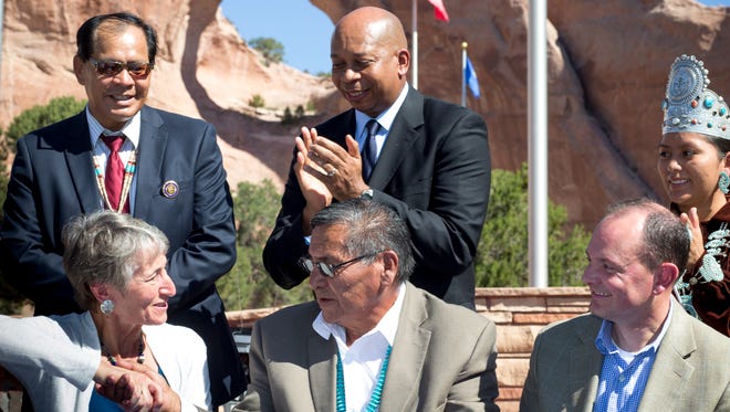 Secretary of the Interior Sally Jewell (left sitting) and Navajo Nation President Ben Shelly (center) shake hands after signing the $554 million settlement on Sept. 26, 2014, at Window Rock.