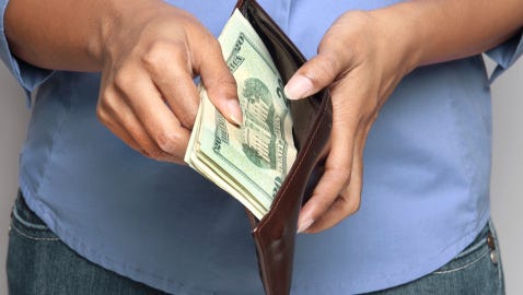Person holding wallet with money