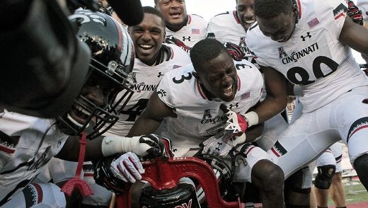 University of Cincinnati players ring the Victory Bell after beating Miami last year.