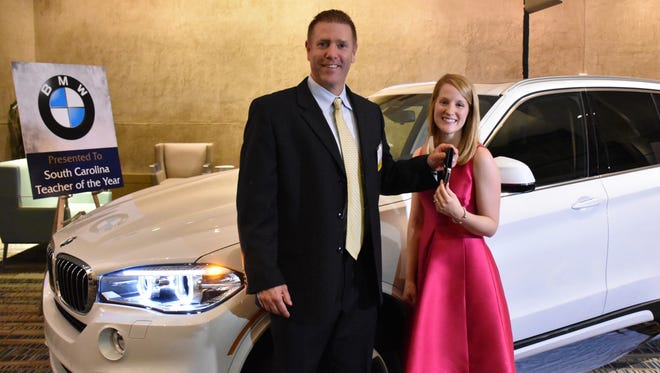 BMW representative Greg Bunner presents the keys of a BMW X5 to Jennifer Wise, the new South Carolina Teacher of the Year.