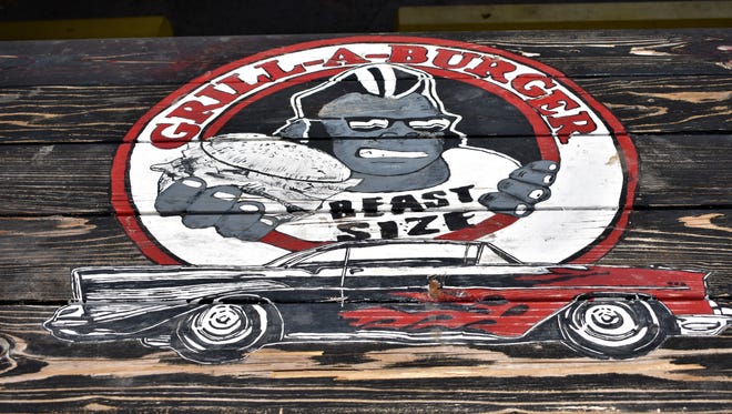 The Grill-A-Burger logo painted on the top of a picnic table on July 6, 2018 at Grill-A-Burger.