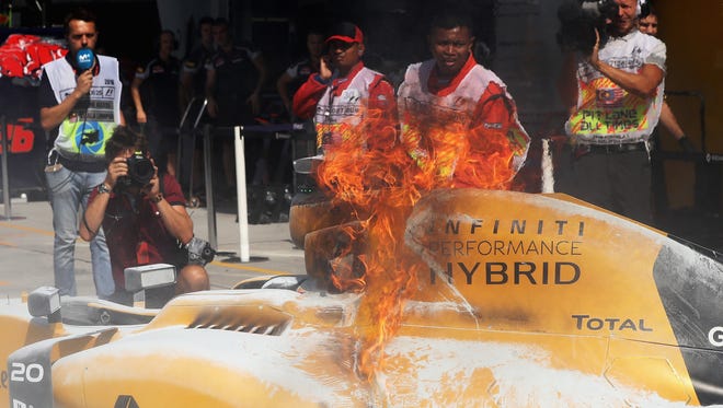 Kevin Magnussen's car is engulfed in flames.