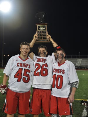 Hoisting the Park championship trophy on May 10 are Canton captains (from left) Nathan Janice (senior), Steven Szymusiak (senior) and Nick Polydoras (junior).