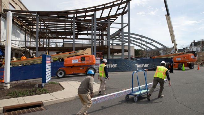Workers carry an autographed beam for Riverview Medical Center's new cancer center in Red Bank.