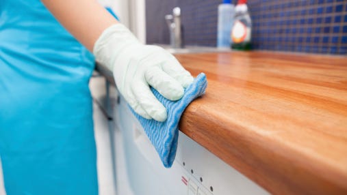 Woman Cleaning Kitchen Countertop