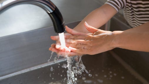 Boy washing hands in water