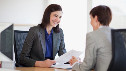 Businesswomen with paperwork talking face to face
