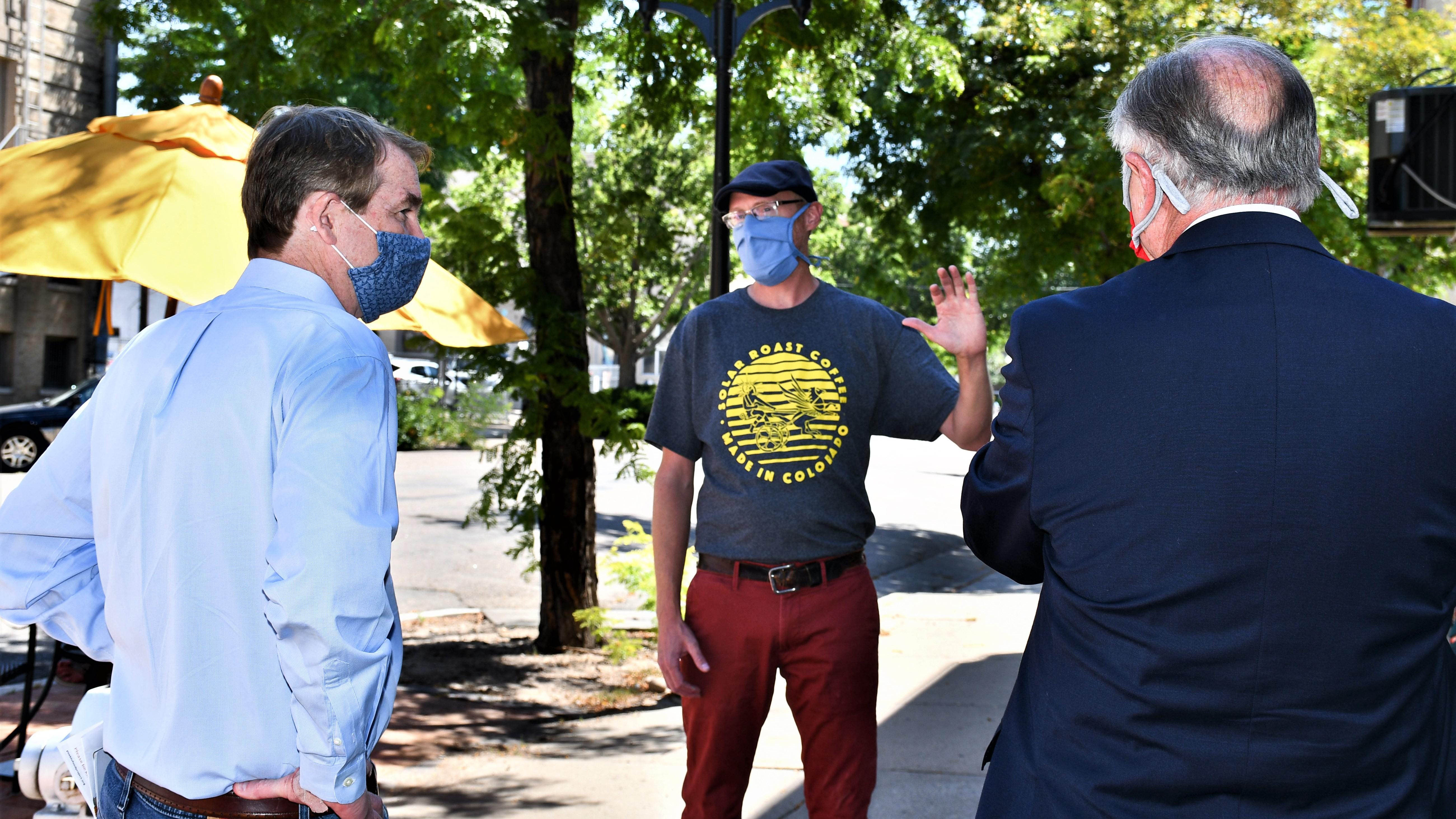 U.S. Sen. Michael Bennet, left, and Mayor Nick Gradisar, right, visit with Solar Roast Coffee owner Mike Hartkop Friday.