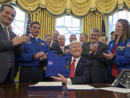 Trump holds a NASA flight jacket presented to him by