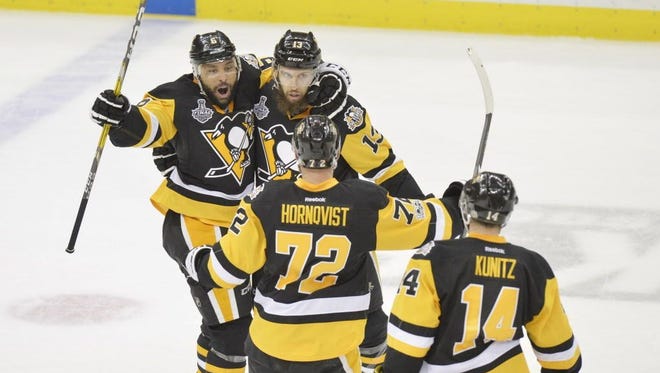 Pittsburgh Penguins center Nick Bonino (13) celebrates with teammates after scoring an empty-net goal against the Nashville Predators during the third period of Game 1.