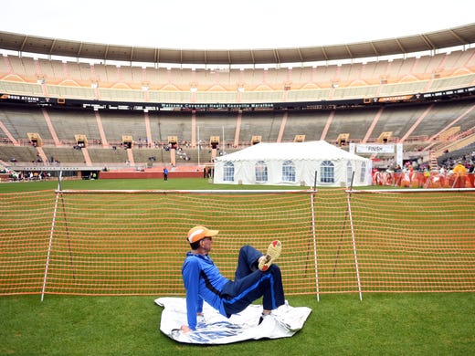 A runner stretches near the finish line in Neyland