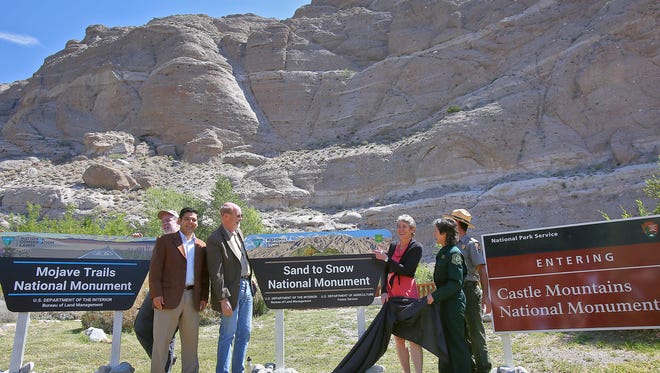Dignitaries pull the wraps off of three signs that will designate three new national monuments during the California Desert National Monuments celebration at the Whitewater Preserve, May 5, 2016.   From left are Jerry Perez, Rep. Raul Ruiz, David Myers, Sally Jewell and Jody Noiron.